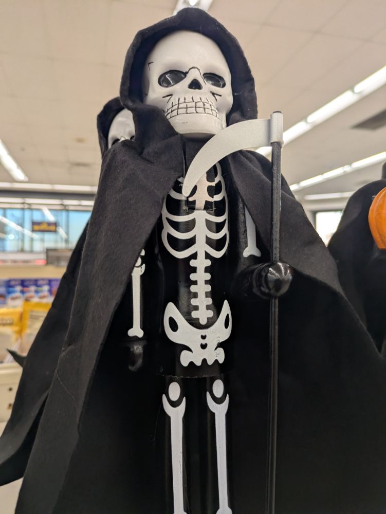 a nutcracker that resembles a classic grim reaper complete with scythe; the actual nutcracking hole is directly under the skeleton's jaw