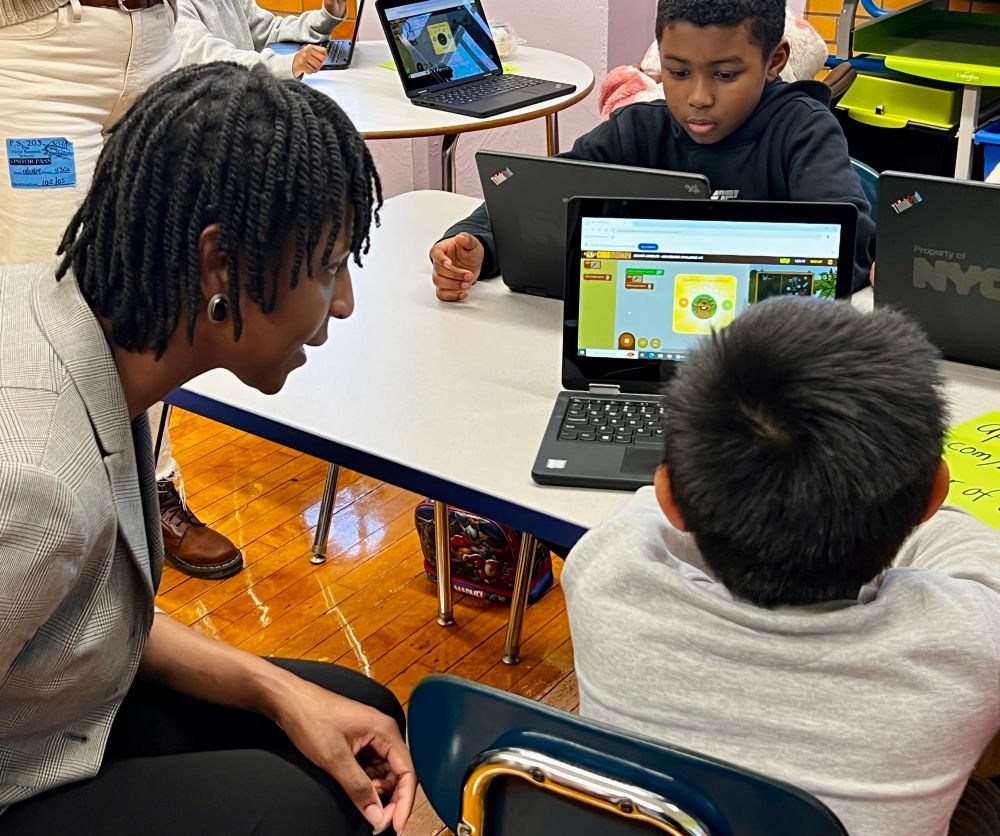 Woman helping young boy with coding