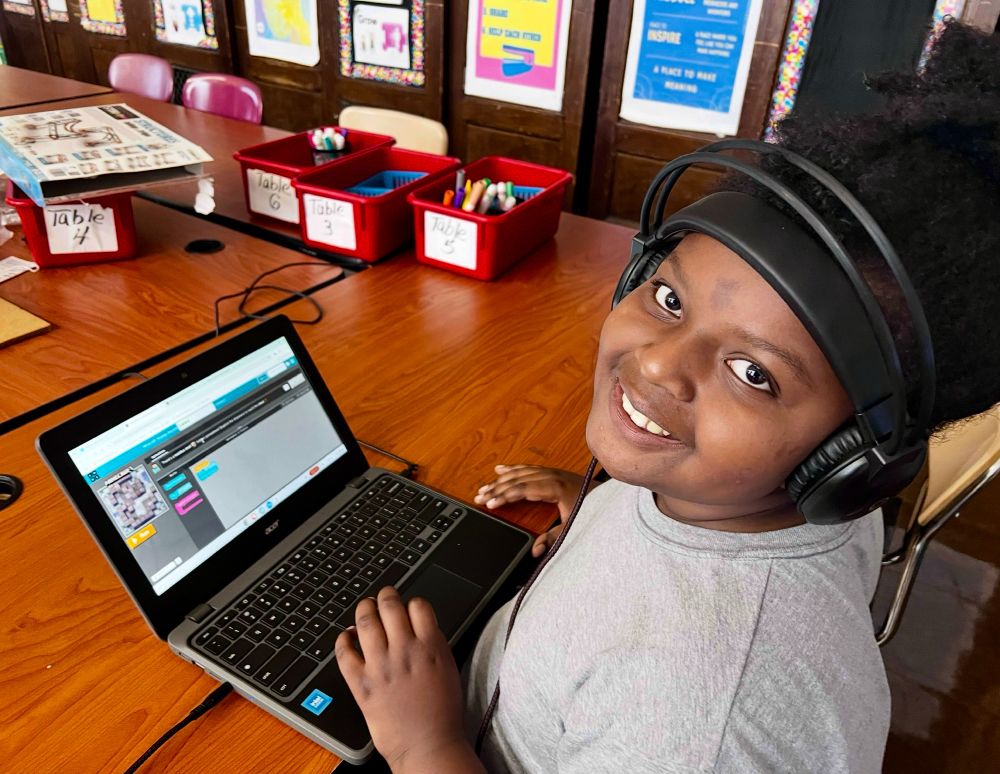 Young girl, smiling by a computer