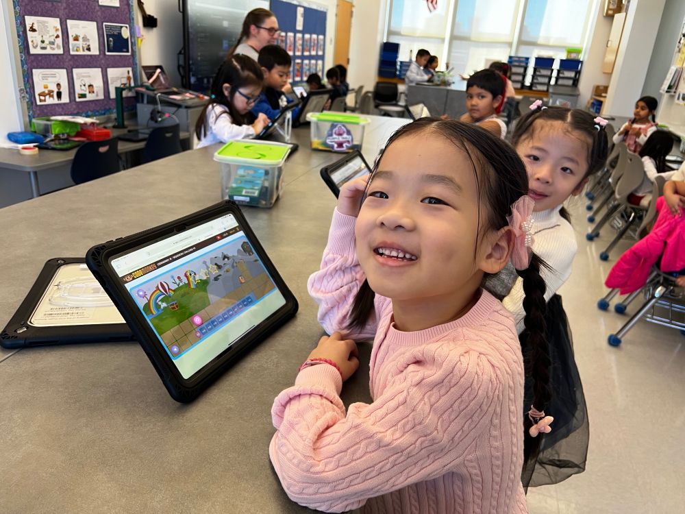 girl coding on ipad and smiling