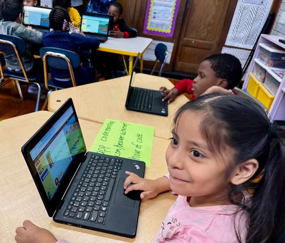 Young girl coding on a computer and smiling