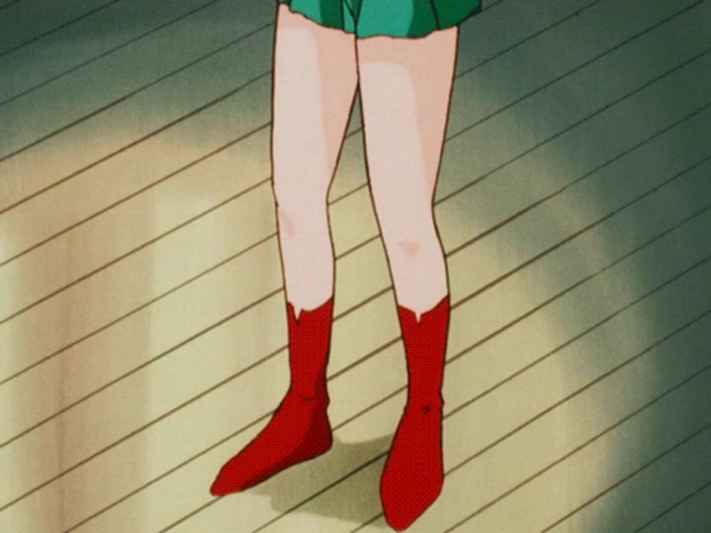 a person wearing red boots with a green skirt