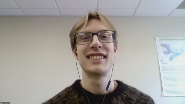 A man smiles for a photo