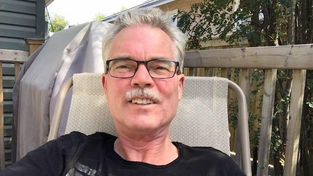 A selfie of a smiling man with grey hair and glasses.