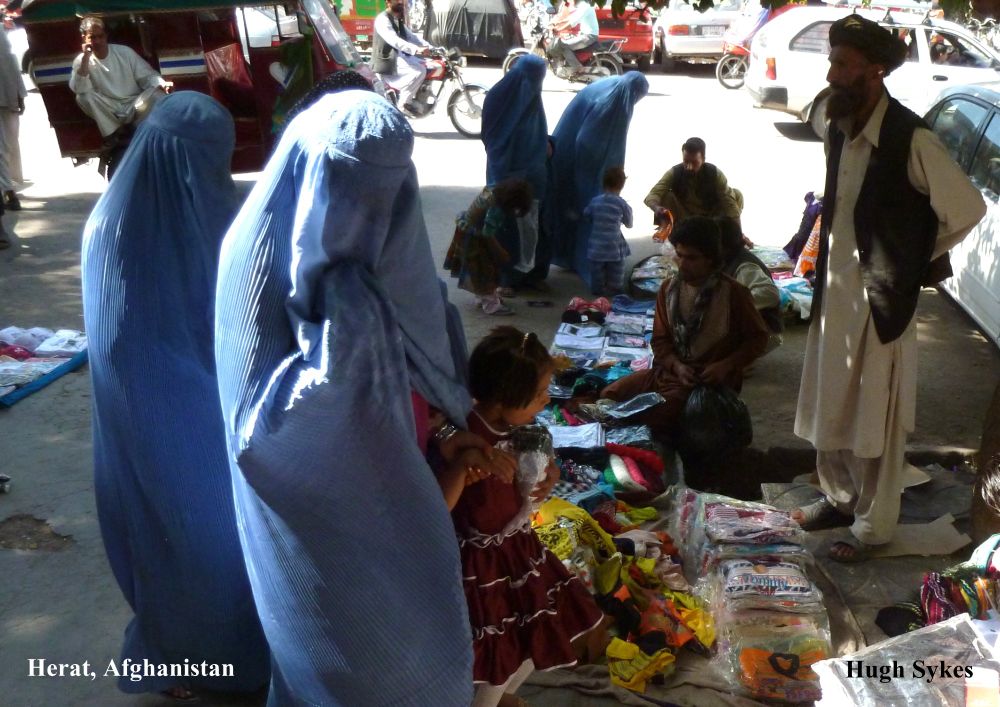Women wearing blue burkas shopping with their children at a street market in Herat in Afghanistan, in 2011. Photo: Hugh Sykes
