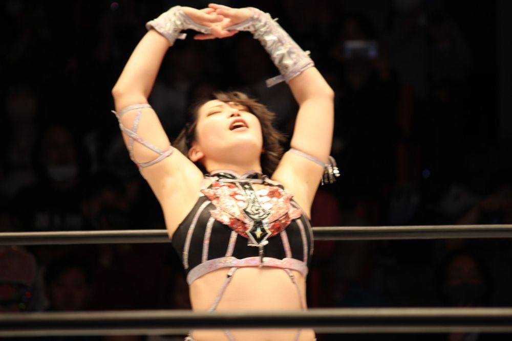 Professional wrestler Utami Hayashishita raises her arms in celebration and relief 