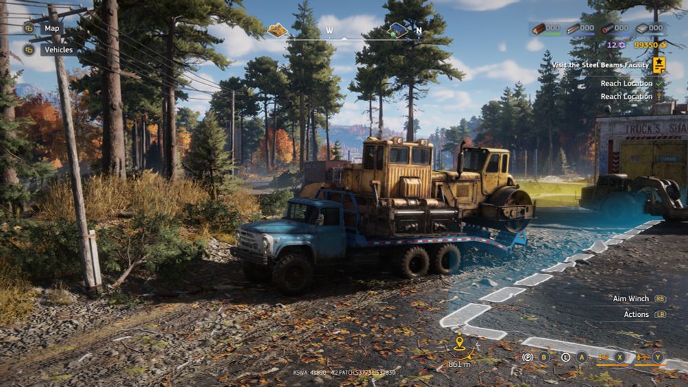 A screenshot from the video game "RoadCraft" showing a transport vehicle carrying an asphalt paver and a roller on its bed. There are trees around with other schrubery you'd see in a forest