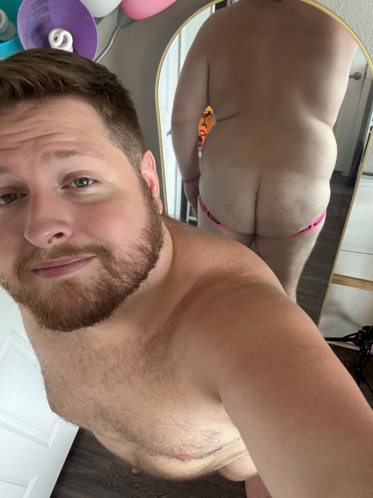 Standing in front of my mirror with my back to it showing off my fat ass in my new jockstrap. 