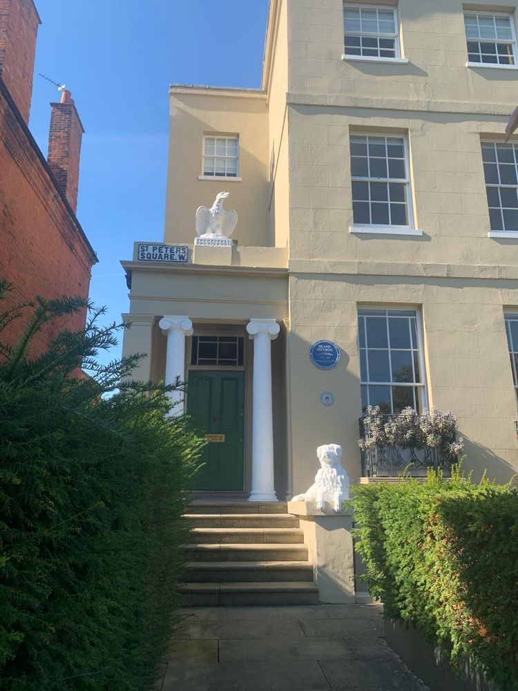 A large Georgian house with a statue of an eagle above the entrance columns. A blue plaque says: Island Records, 1973 to 2005. 