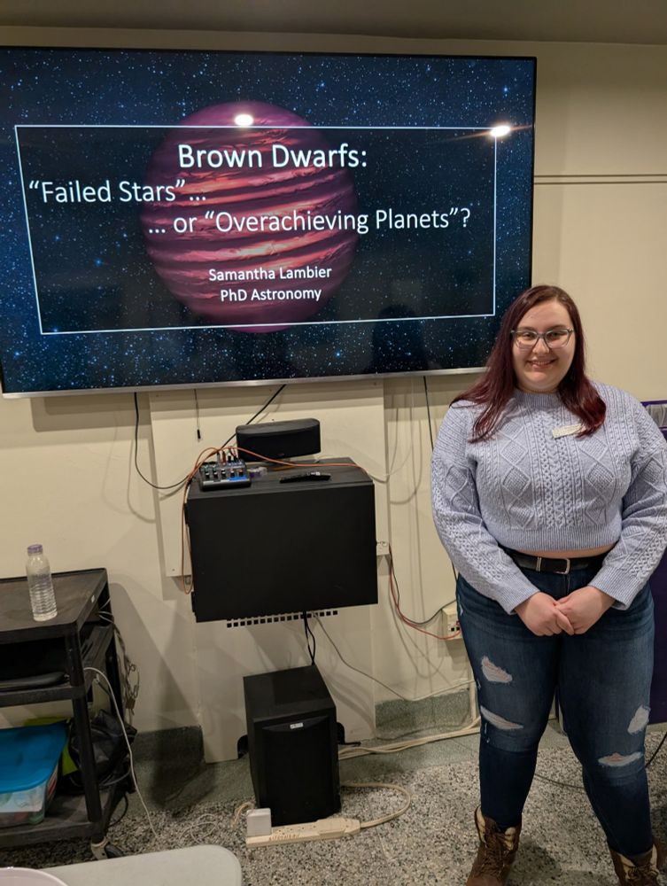 A photo of me standing in front of the TV in the Cronyn Observatory classroom. On the screen is a slide which reads "Brown Dwarfs: 'Failed Stars' ... Or 'Overachieving Planets'?"