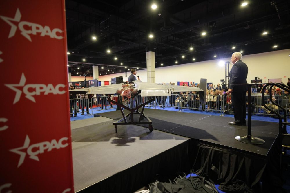 rear of the captured drone on the CPAC stage with white haired white dude