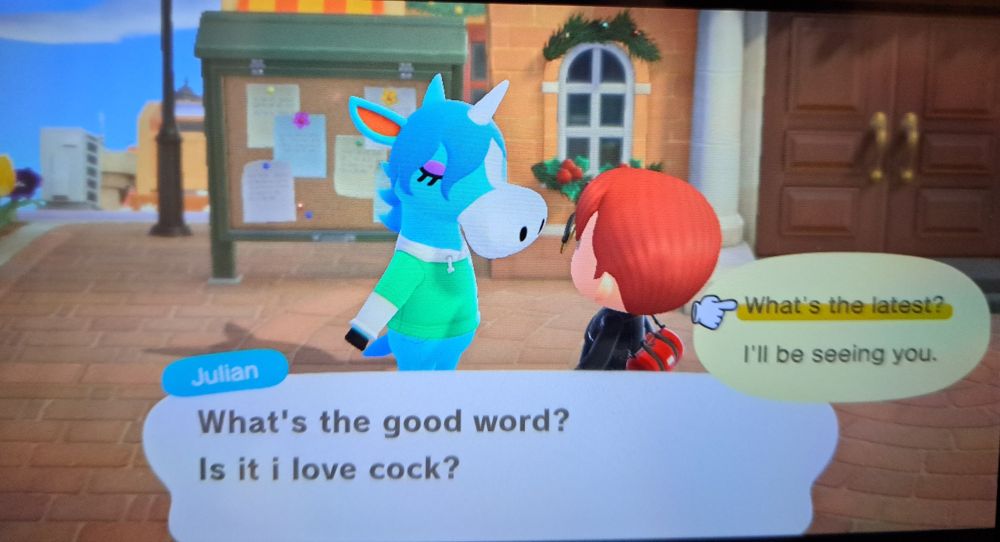 A screenshot of Julian the unicorn from animal crossing talking to my red headed avatar saying. "What's the good word? Is it i love cock?" 