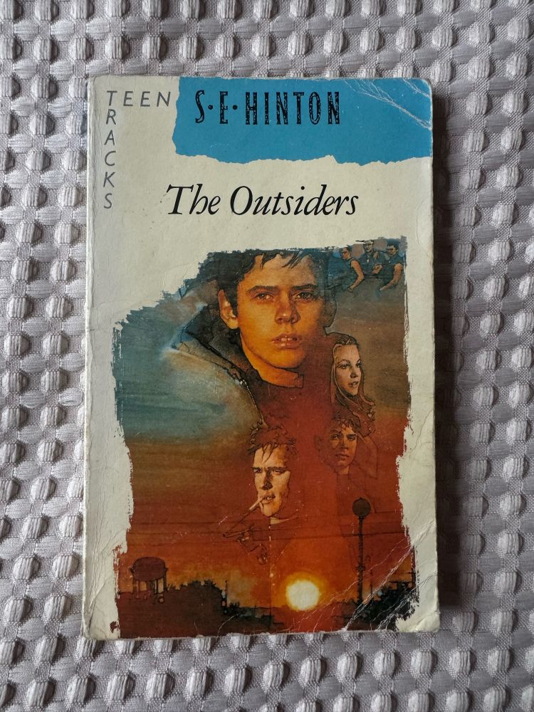 A picture of a worn paperback copy of The Outsiders by S. E. Hinton