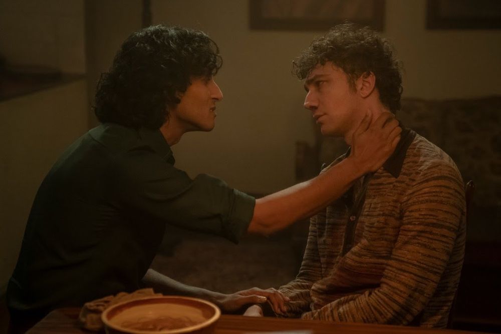 Screenshot of IWTV S2E5 (Don’t be afraid, just start the tape) 

Armand (left) and young Daniel sitting at a table. Armand has one hand on Daniel’s wrist, one on his neck, trying to convince They're looking into each other's eyes. Armand’s demeanor is gentle. Daniel looks sad and skeptical about whether low blood sugar is a good enough excuse for Armand’s earlier behavior.