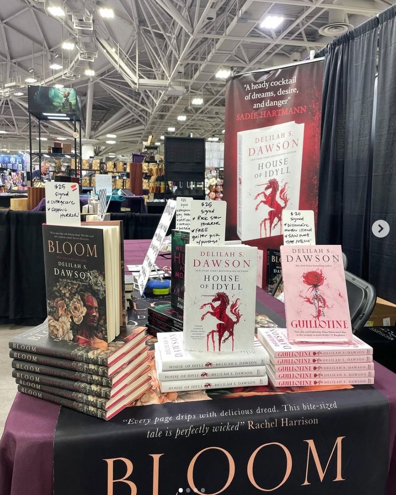The endcap of Delilah's booth #756 shows her three Horror novellas from Titan, fetchingly stacked atop a Bloom tablecloth with cute lil shelf talkers of which she is exceedingly proud.