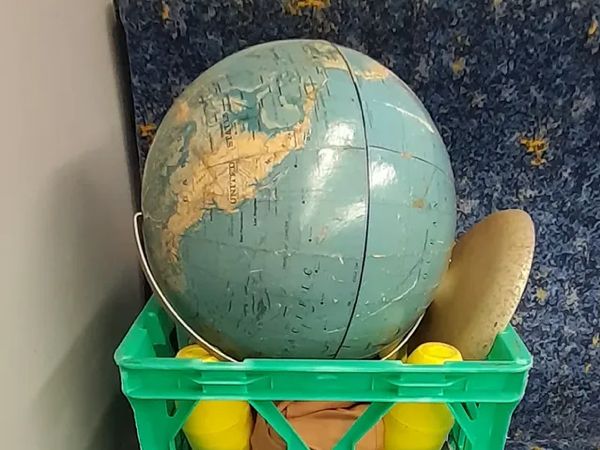 a globe in a milkcrate on a train seat