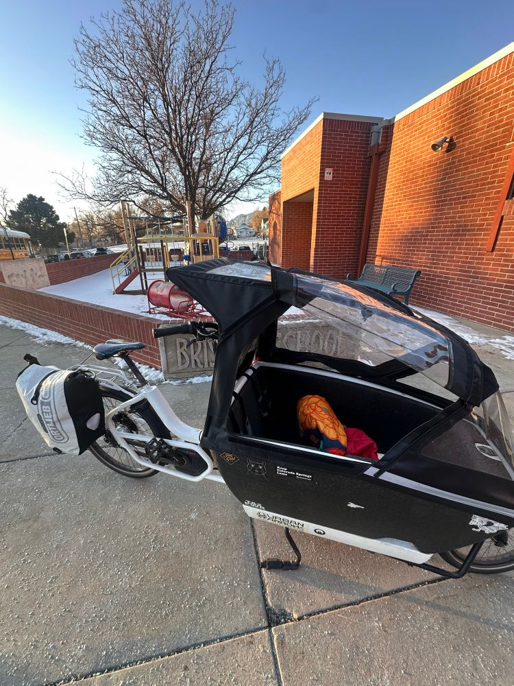 Cargo bike parked in front of a school playground after Kid was dropped off for school