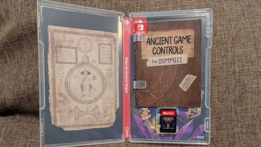 Geöffnete Hülle von Simon The Sorcerer Origins, über dem Modul ist ein kleines Booklet mit der Aufschrift "Ancient Game Controls for Dummies" in der Hülle.