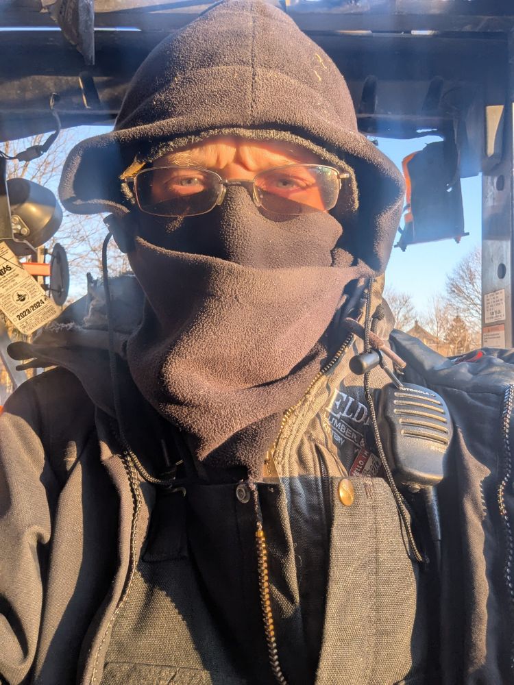 Selfie bundled up in enough clothing that only the eyes are visible behind slightly tinted glasses.
