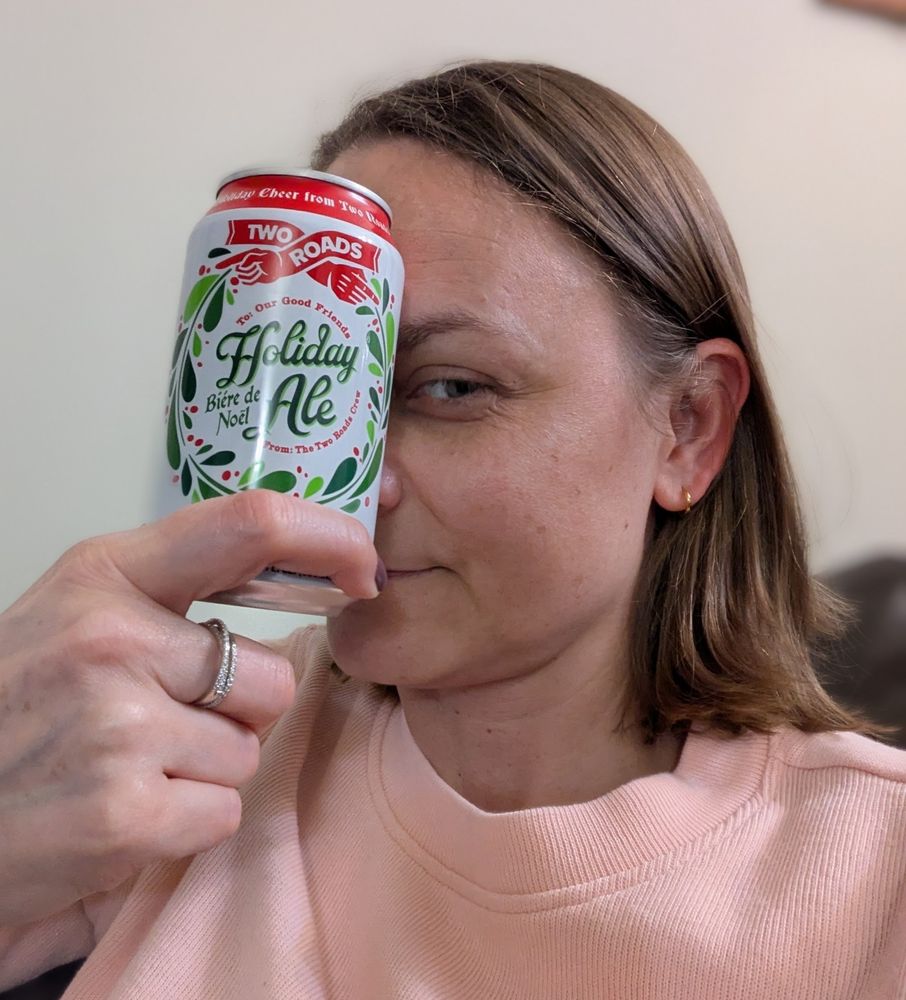 Woman holding a can of Two Roads Holiday Ale.