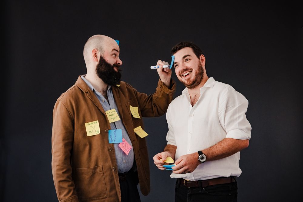 Matt covered in post-it notes, adds one to Duncan head and draws on it with intent!