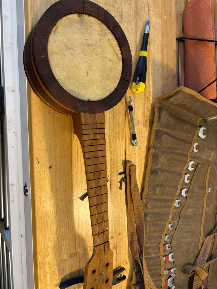 Banjo ukulele in non-playable condition. Missing frets, tuning pegs, a bridge, and strings