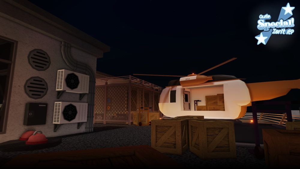 A rooftop photo overlooking a delivery in progress, with various roof-top equipment present from left to right. An orange and white helicopter can be seen behind a pile of wooden crates.