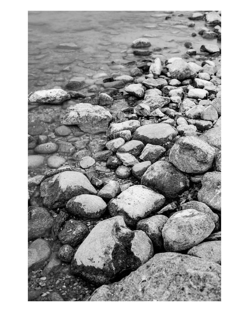 A black-and-white photograph of rocks on the shore of Lake Michigan