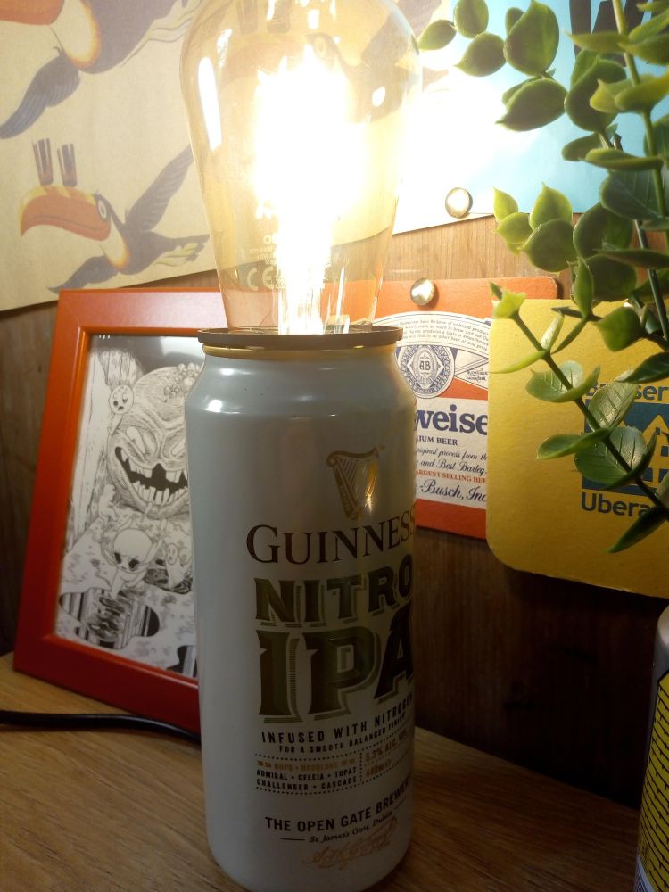 Photo d'une canette de bière, Guinness Nitro IPA, dont le dessus est ouvert et dans lequel j'ai placé une ampoule pour faire une lampe d'ambiance de schlag