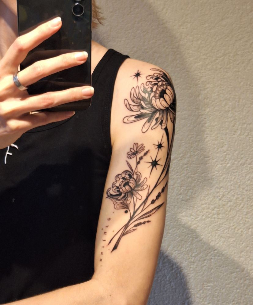 my new tattoo on my shoulder: chrysanthemums, daisies, lavender and stars, and the word "nurture" 