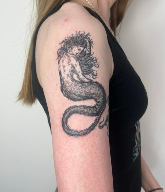 Side profile of June’s right arm with a fresh mermaid/siren tattoo 