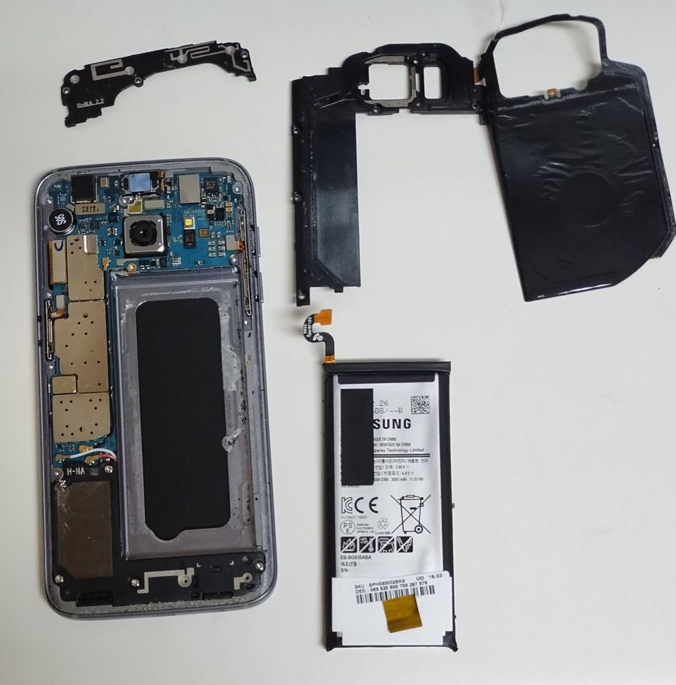 partially disassembled samsung galaxy s7 with old battery removed so i can replace it and repurpose the phone which is tbh still pretty decent even for being so old anyway hi