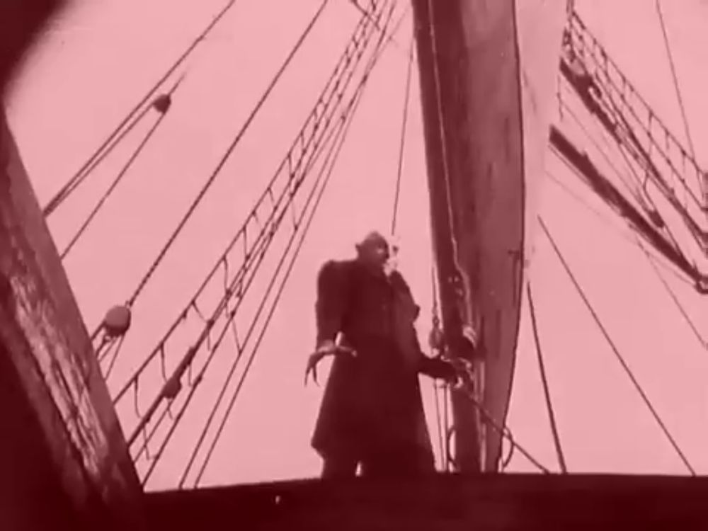 nosferatu from the 1922 film standing at an intimidating angle with a red tint (this is unedited from the film)