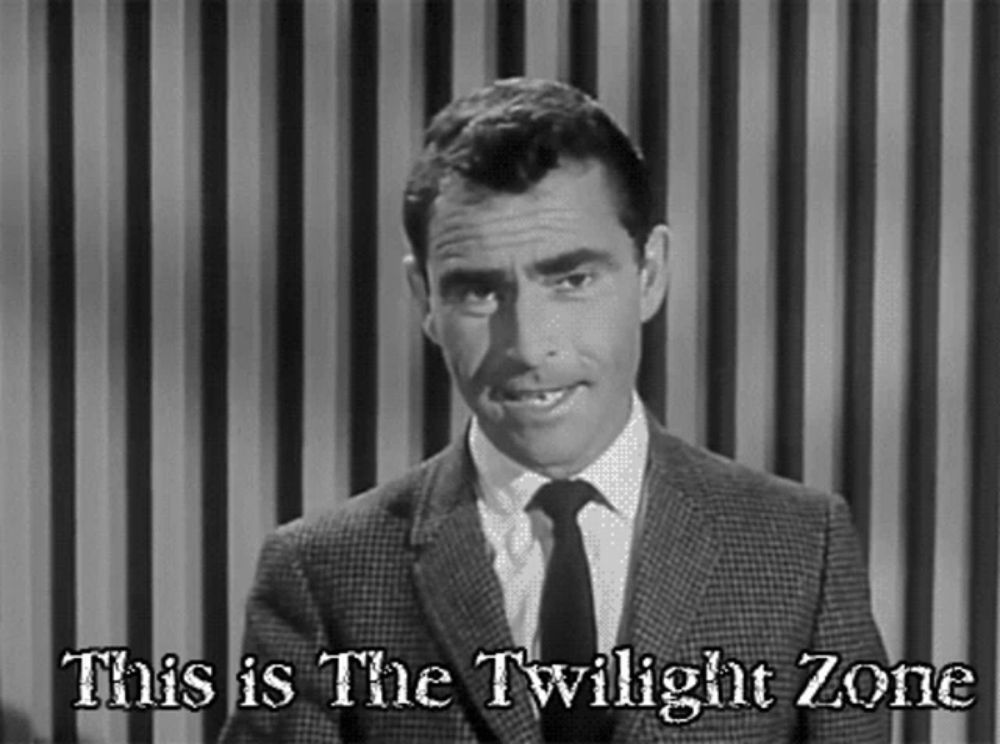 a man in a suit and tie is standing in front of a striped curtain and says this is the twilight zone