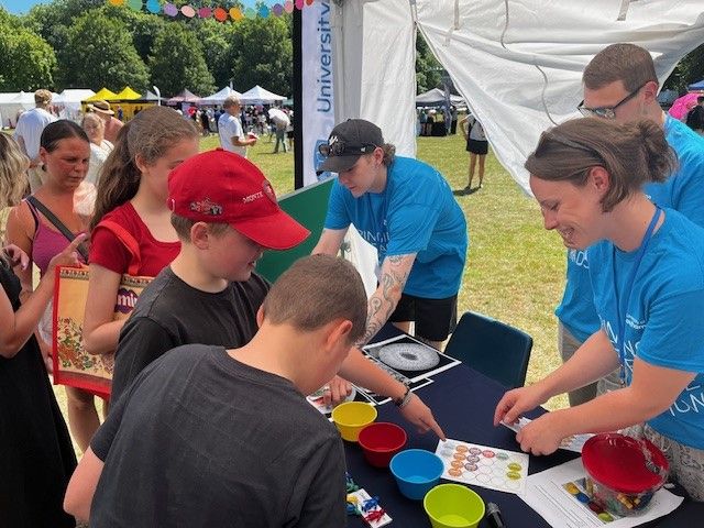 A group of children playing science activities, with researchers from the Southampton Clinical Trials Unit.