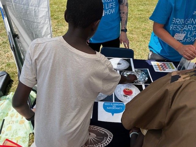 The back of a young boy playing a game to match MRI scans of fruit and vegetables with the correct fruit or vegetable.