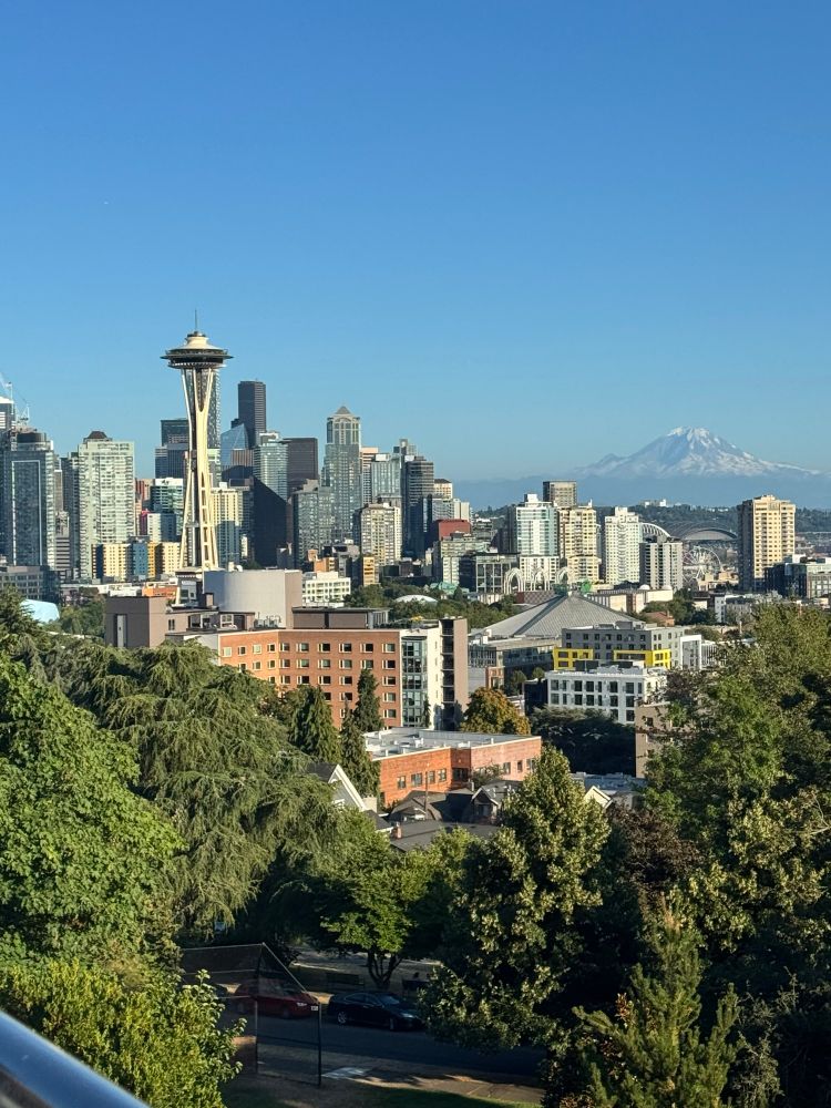 Seattle skyline. Mount Rainier (Tahoma) in the background. The sky is blue and cloudless.