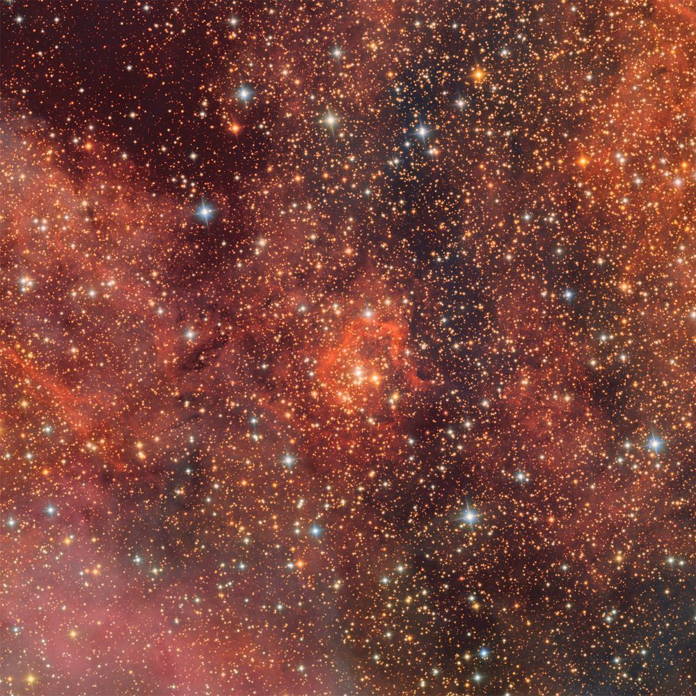 Dense field of blue and yellow stars against a vibrant, glowing backdrop of orange and red nebula clouds.