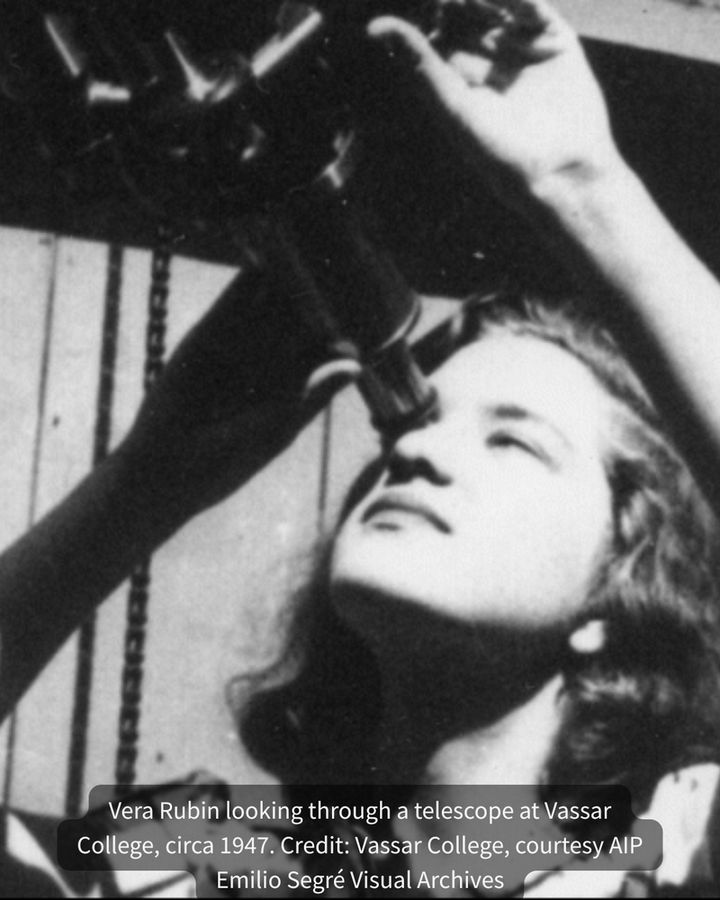 Black and white photo of a young Vera Rubin looking up through a telescope