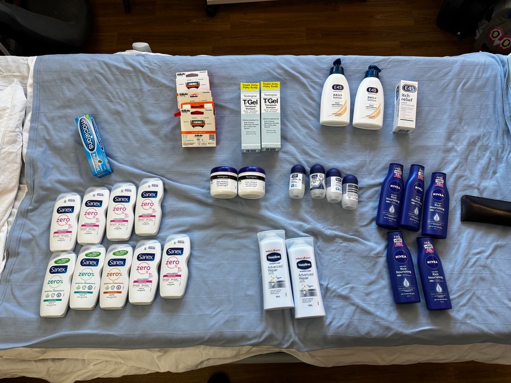 Photograph of a bed cupboard with around 10 bottles of shower gel, and eight bottles of body cream of various manufacturers.