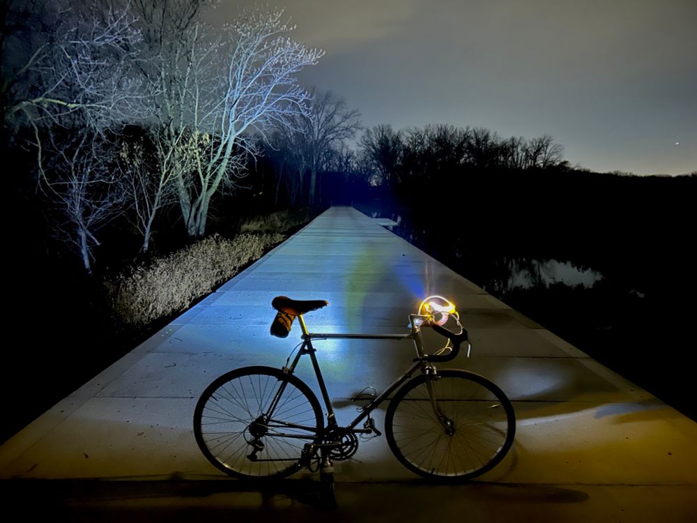 Bike on a cement bridge across a fen. 