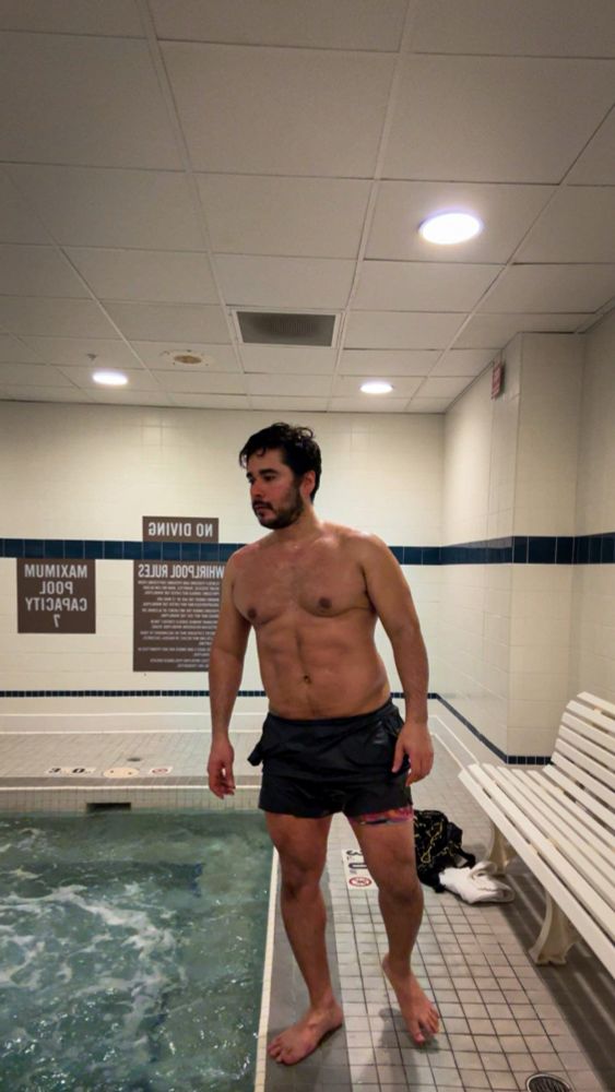 Sweaty shirtless fit scruffy male, barefoot  by the whirlpool