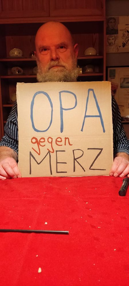 Ich halte ein Demoschild in die Kamera, darauf steht: OPA gegen MERZ.