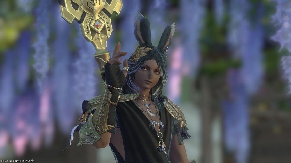 a male viera from final fantasy xiv, with brown skin and dark shaggy hair with silver streaks. he looks off to his right past the camera, waving and smiling a little. he's dressed in black and gold.