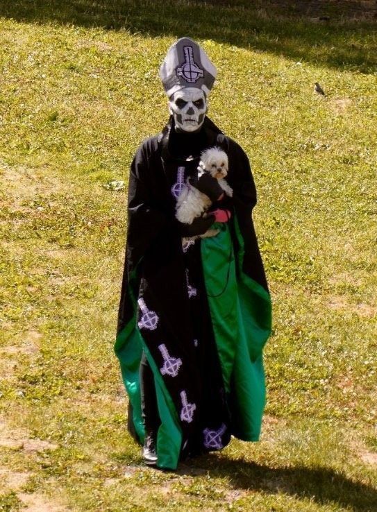Papa II/Secondo holding a fluffy little dog.