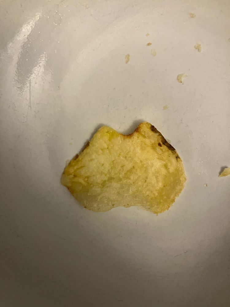 A photo of a single pale-yellow potato chip in the bottom of a bowl. It is the shape of Australia. But Chip Tasmania has got misplaced and is lying off the east coast of Chip Brisbane. A 12 year old ate this chip moments after the photo was taken. He said “it was good”.