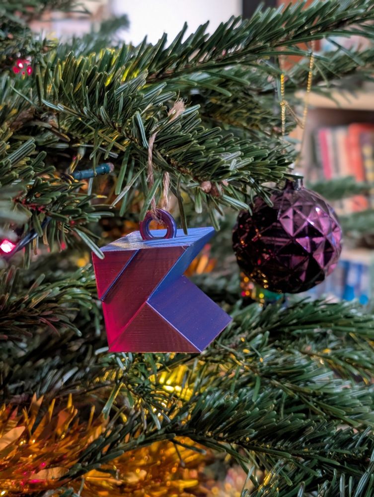 A tree ornament of the Kotlin logo on a Christmas tree