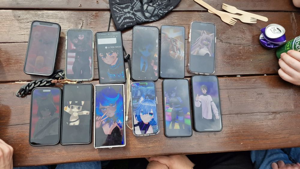 Group photo of people's VRChat avatars on their phones on a table