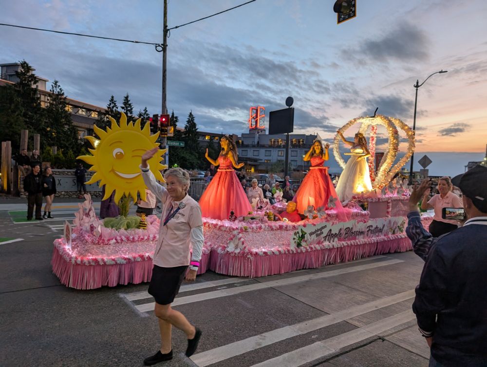 Apple Blossom Festival float, pink with a yellow sun and princesses (maybe?) in fancy dresses