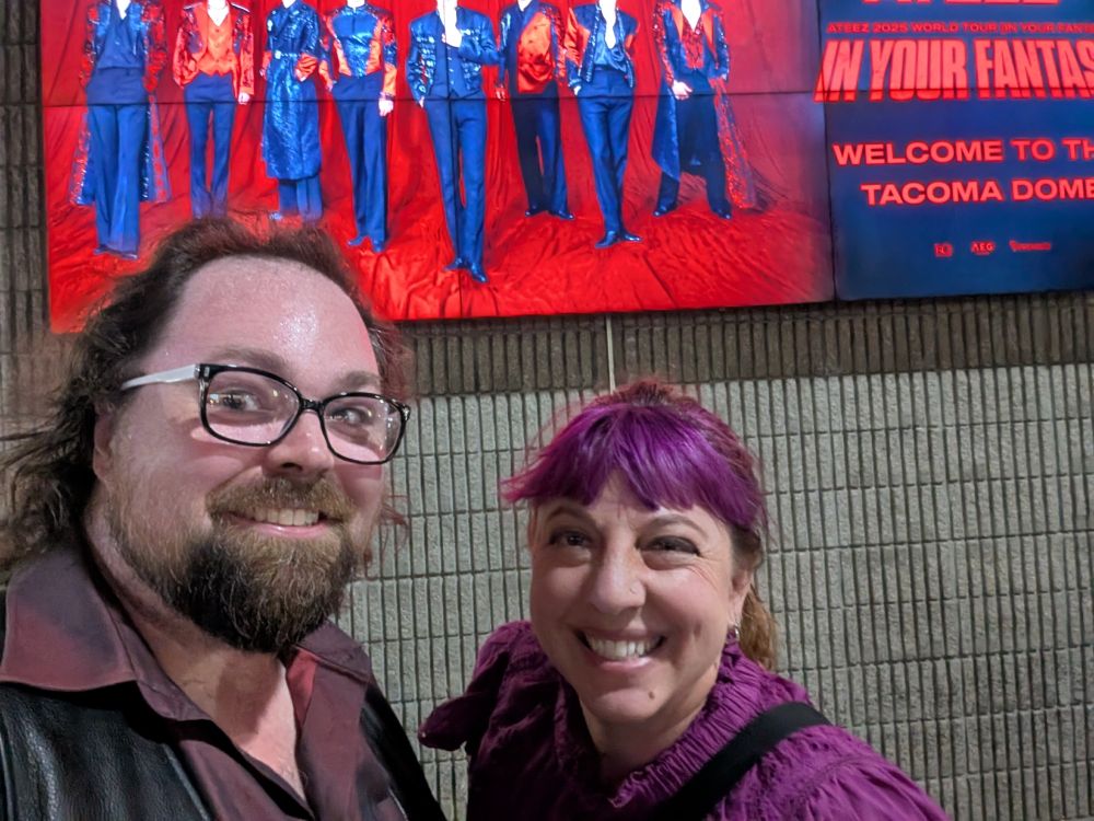 Nathaniel and Rachel in front of the ATEEZ sign at the Tacoma Dome